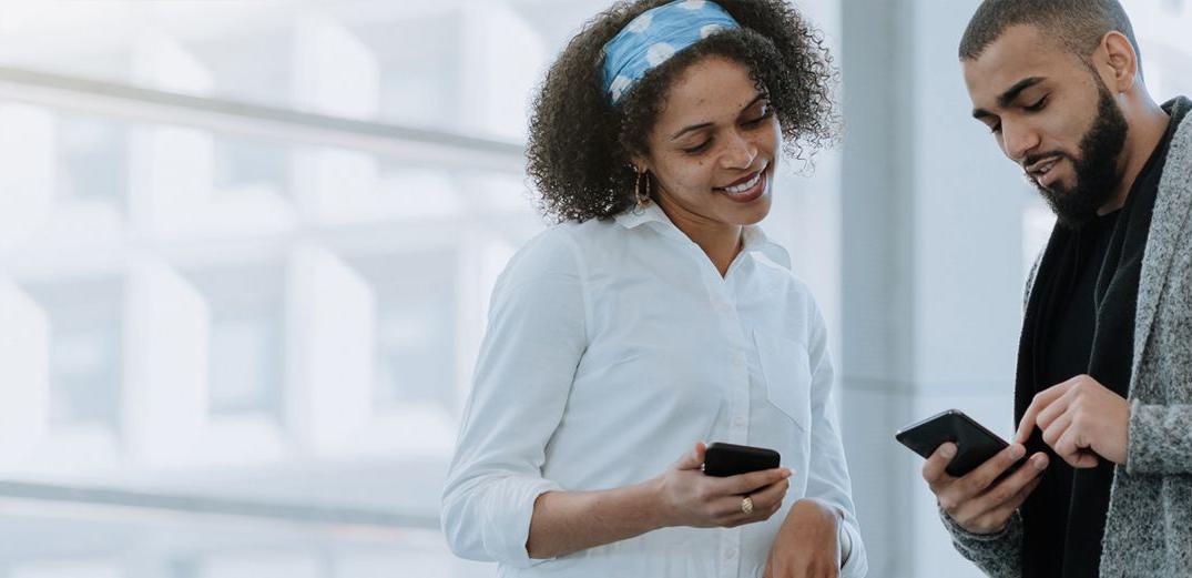 A Millennial shows a friend how to check her accounts on a phone with Patelco Online.